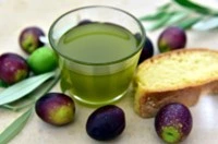 Ciotola di olio extravergine di oliva con crostino, olive invaiate e foglie di ulivo nella Fattoria Donna Tina, Basilicata