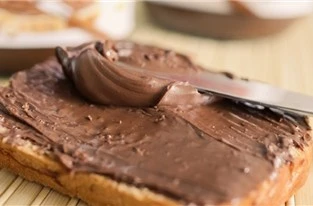 Fetta di pane rustico con crema spalmabile al latte di asina su sfondo naturale a Stigliano