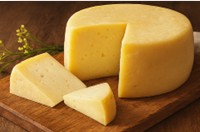 Forma di formaggio semistagionato artigianale della Latteria Donna Tina, presentata su tagliere di rovere.