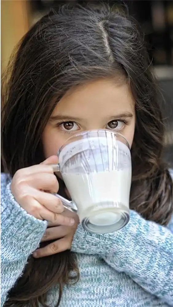 Bambina che beve yogurt da bere Donna Tina a base di latte di asina.